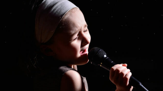young girl singing into mic